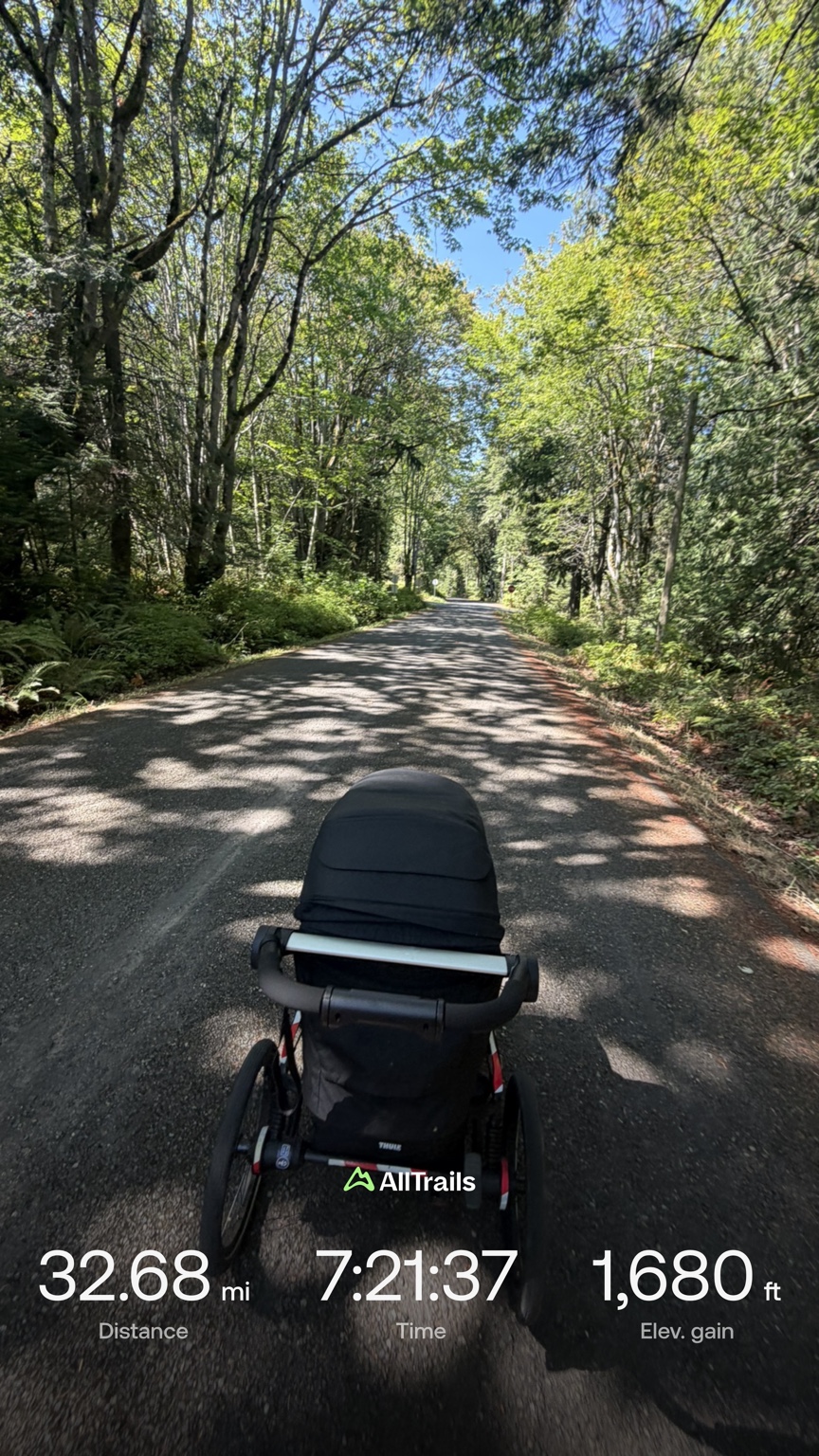 View over Matthew’s running stroller on a tree-lined stretch of the Olympic Discovery Trail after 32.68 miles on Day 5