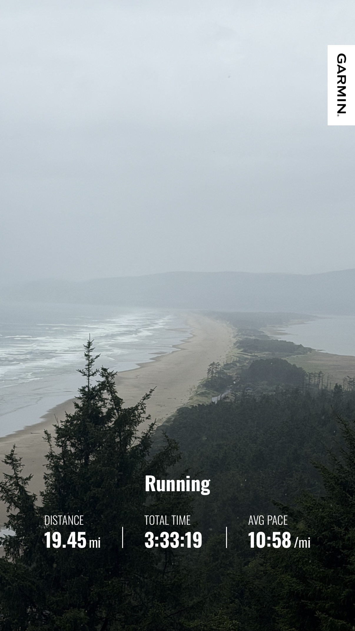 Rainy view over the Oregon Coast with Matthew’s Garmin summary showing a 19.45-mile run from Netarts to Pacific City
