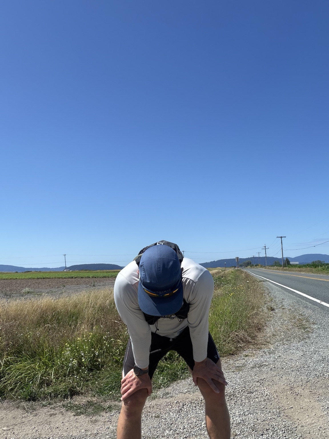 Matthew bent over catching his breath beside a long rural road