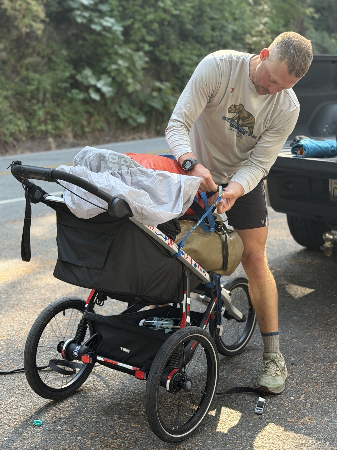 Matthew securing gear to his running cart during a roadside stop