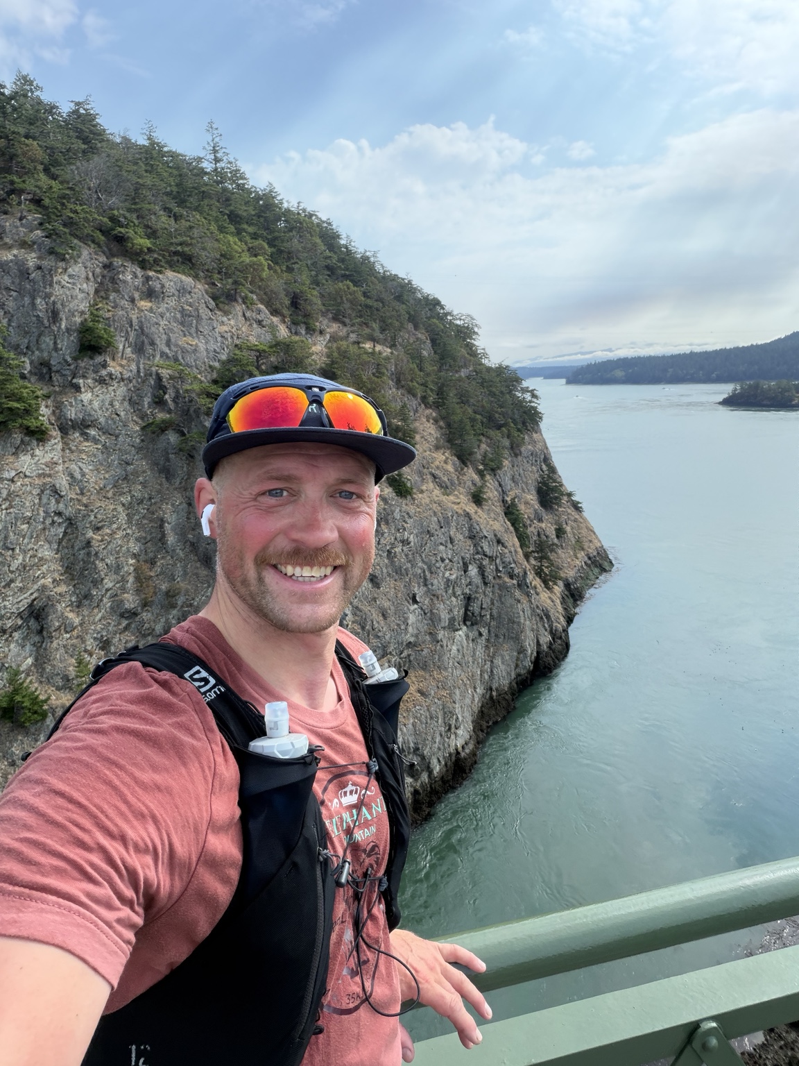 Matthew smiling above the water and cliffs at Deception Pass