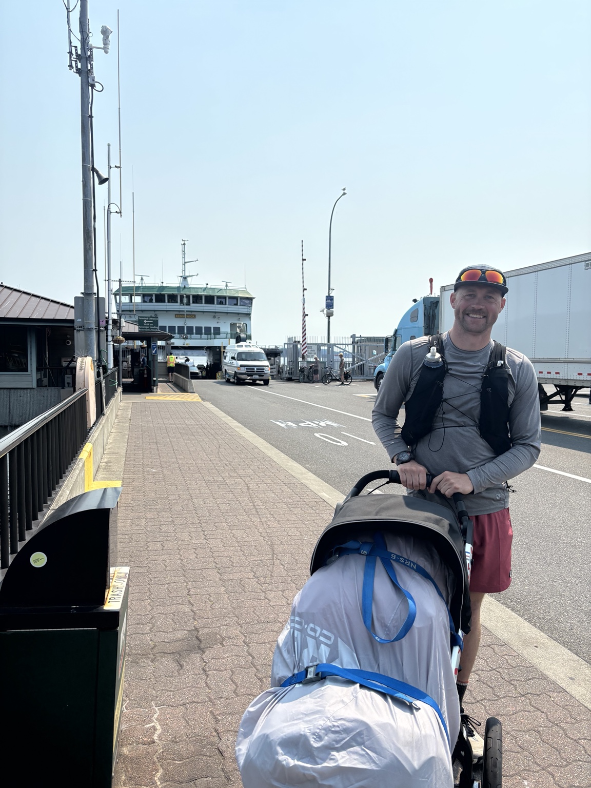 Matthew smiling with his loaded running stroller at the Coupeville ferry terminal
