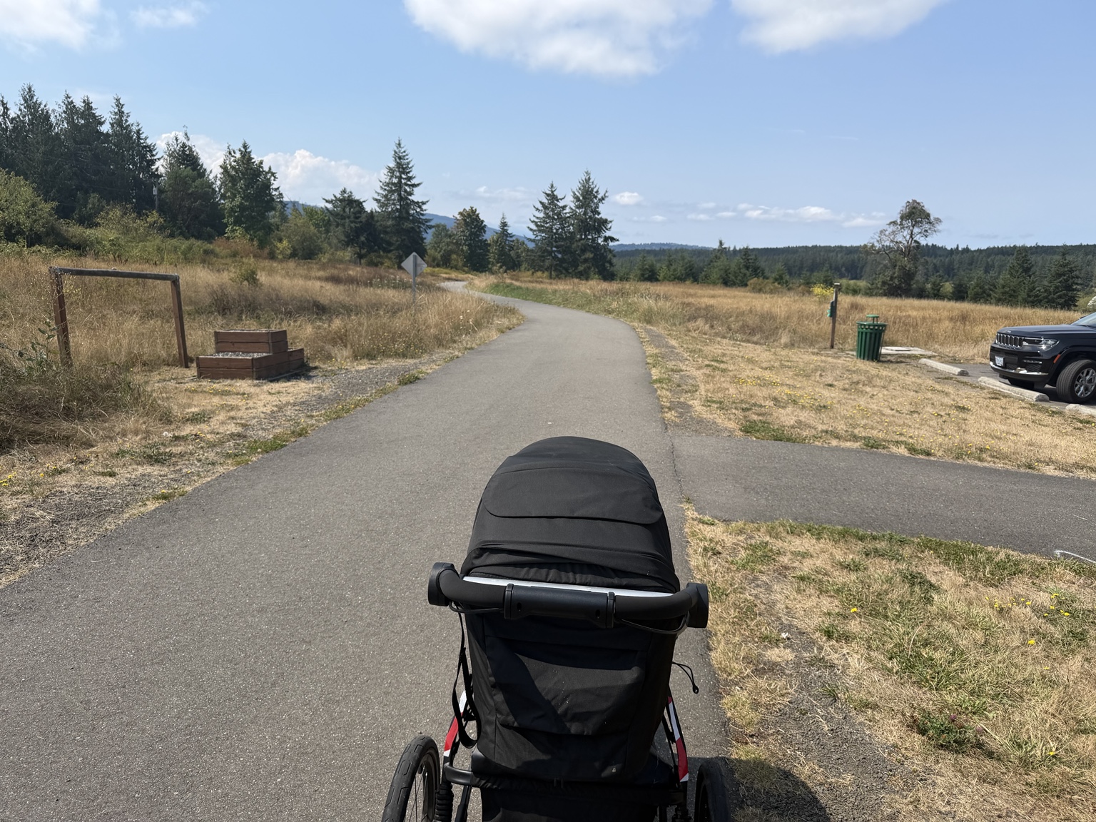 View over the running stroller on the Olympic Discovery Trail through open grassland
