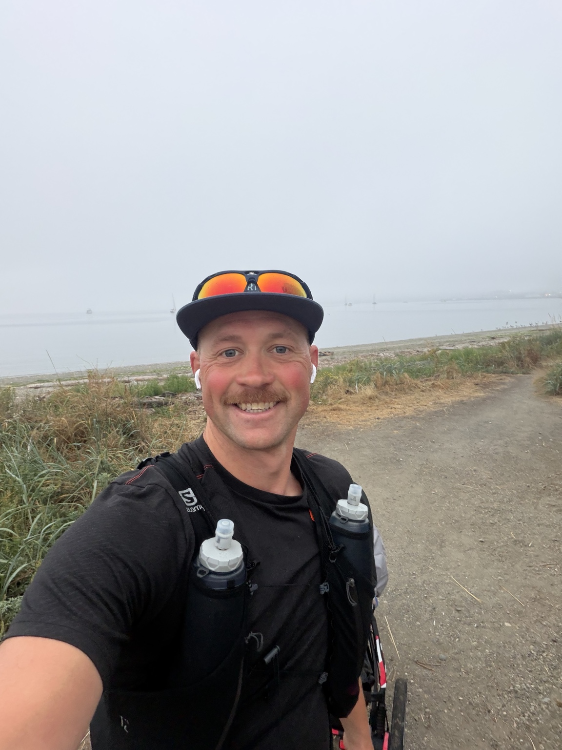 Matthew smiling beside a foggy waterfront during Day 5
