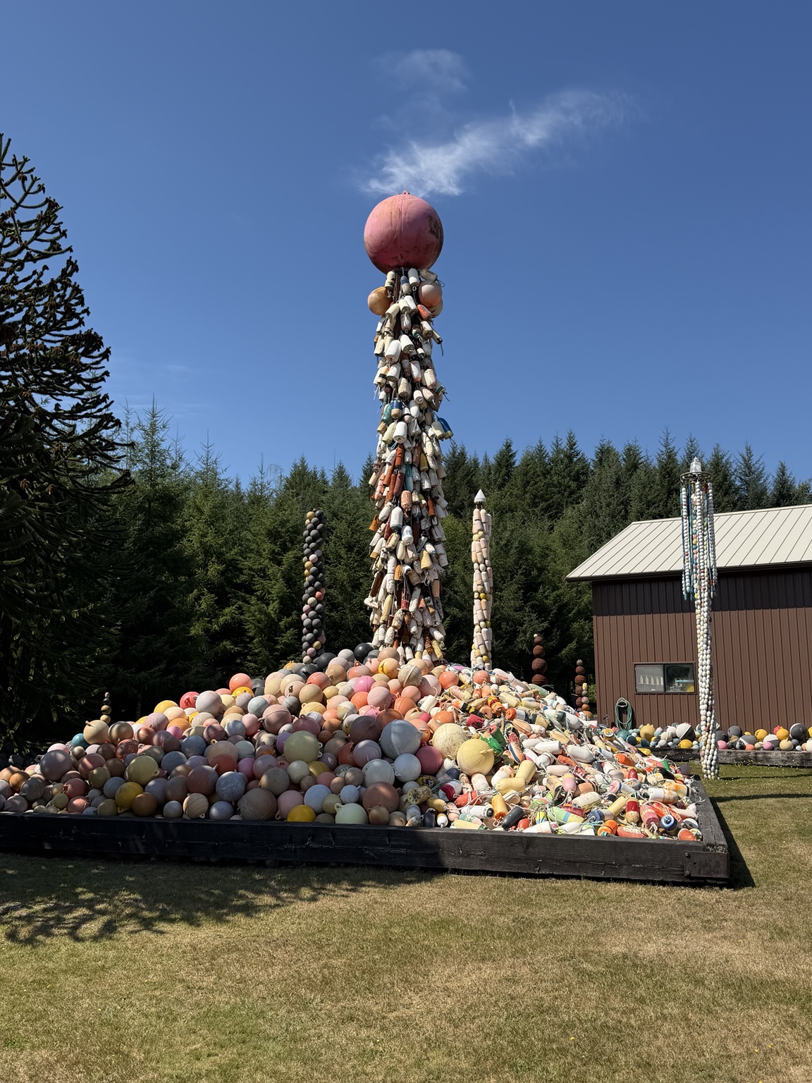 A towering outdoor sculpture built from hundreds of colorful fishing floats