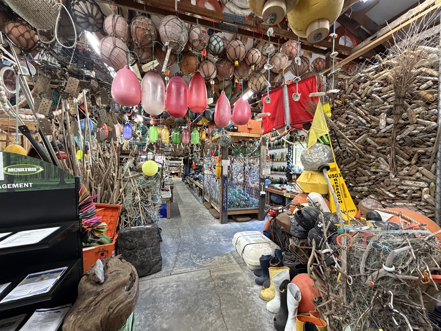A workshop packed with colorful fishing floats, nets, ropes, and beach finds
