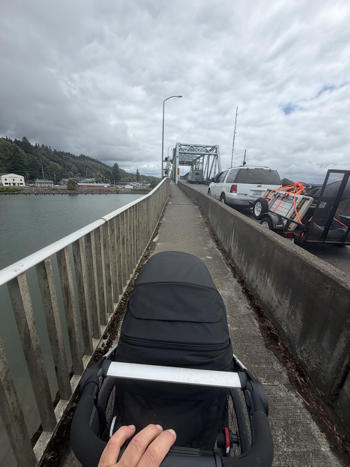 Matthew pushing his stroller along the narrow sidewalk of a bridge into Aberdeen