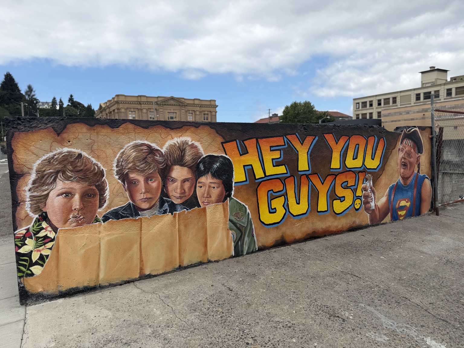 A colorful Goonies mural reading Hey You Guys in downtown Astoria