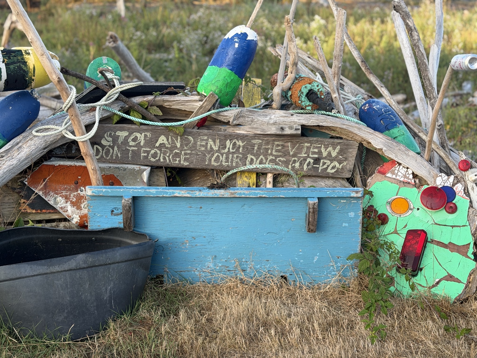 A colorful roadside collection of driftwood, fishing floats, and reclaimed coastal objects