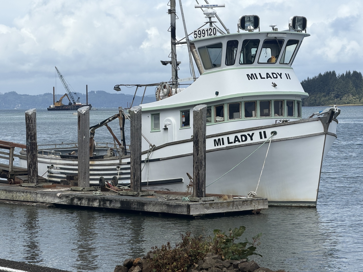 The fishing boat Mi Lady II tied to a dock beneath a bright coastal sky
