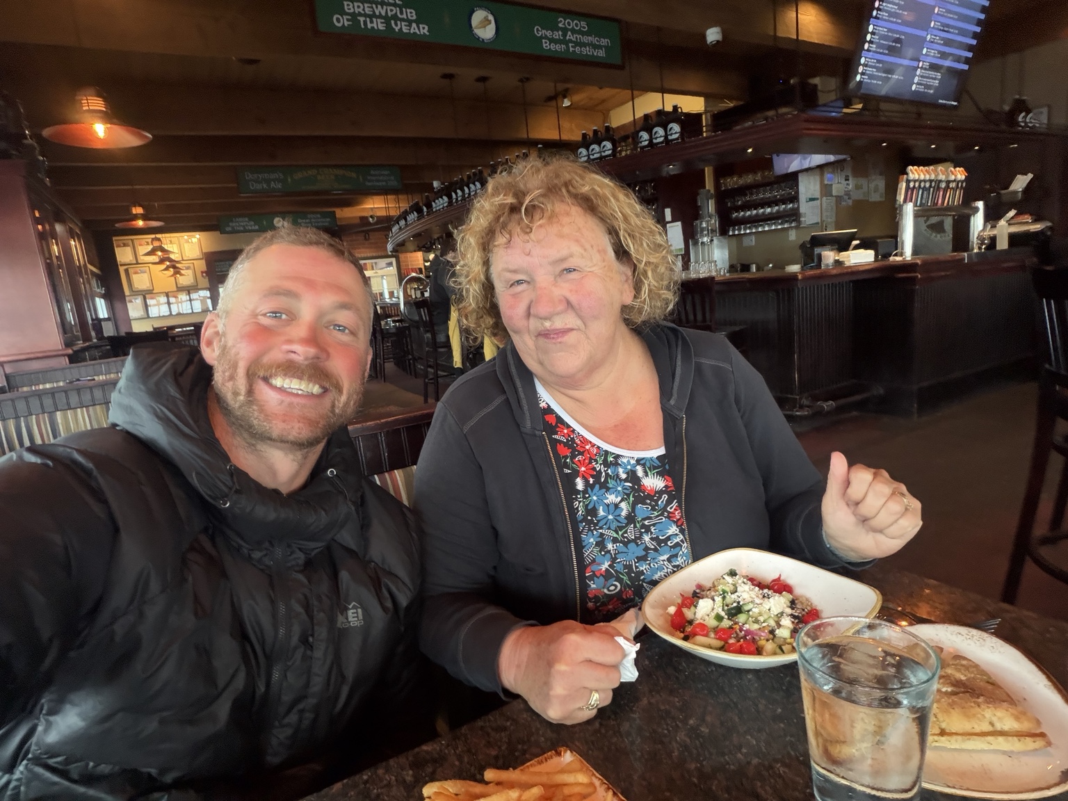 Matthew and his mother smiling over a meal at Pelican Brewing in Pacific City