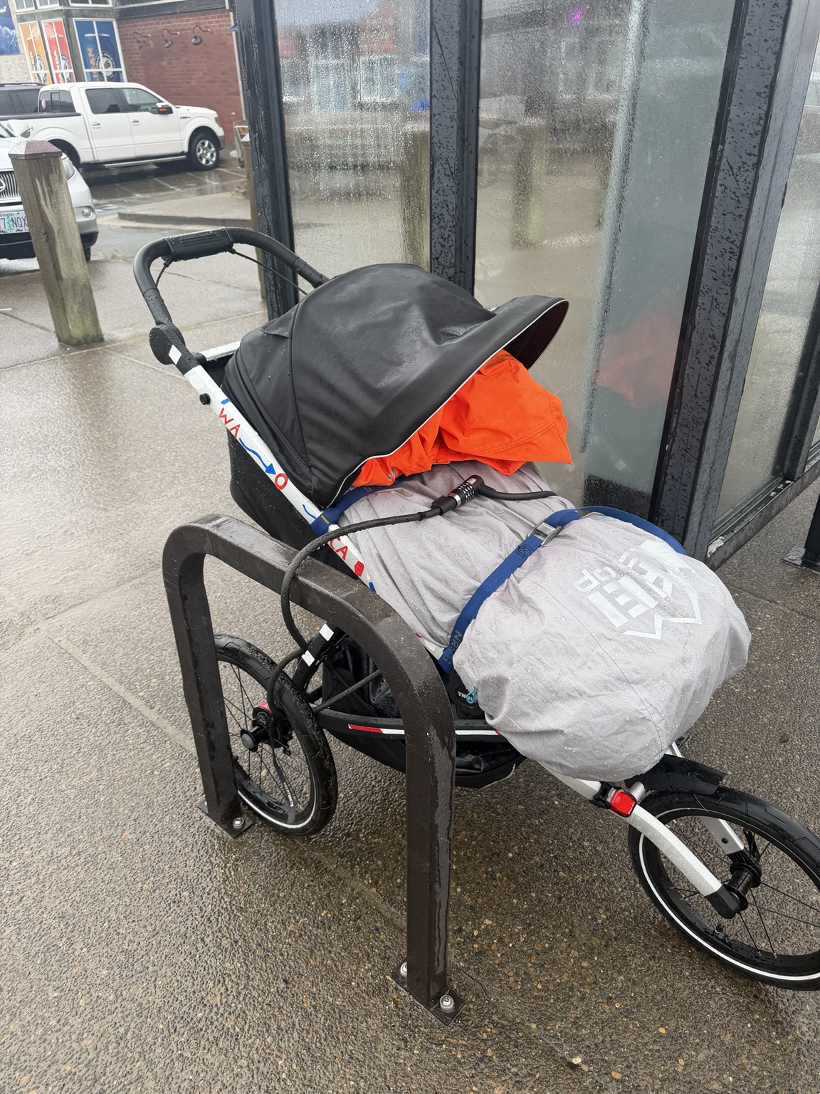 Matthew’s rain-soaked running stroller parked beneath a shelter during the run to Pacific City
