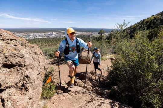 Matthew climbing a rocky trail with trekking poles