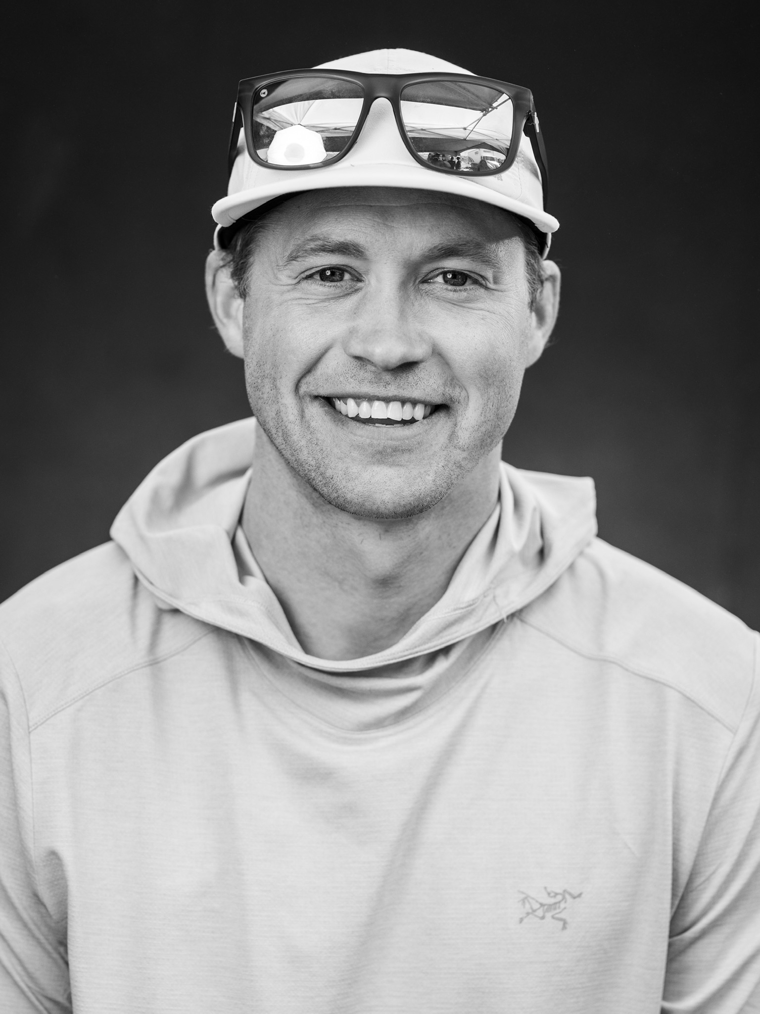 Black-and-white portrait of Matthew Tiscornia wearing a running cap and sunglasses