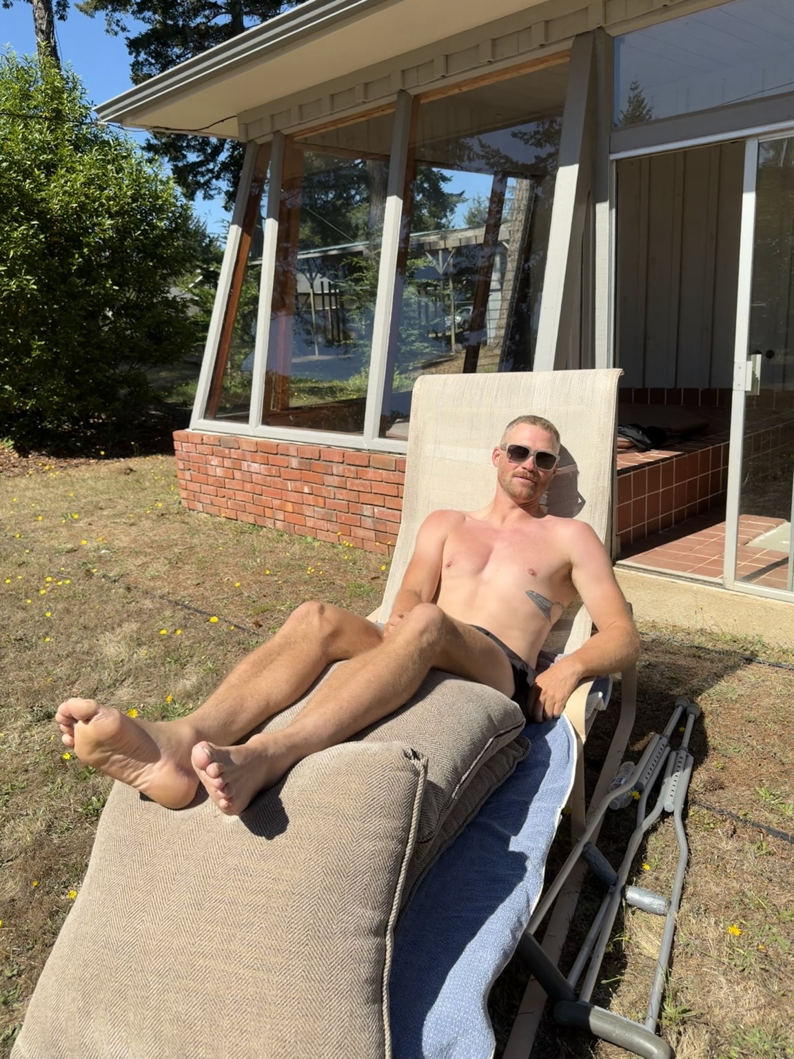 Matthew resting in the sunshine with his crutches beside the chair